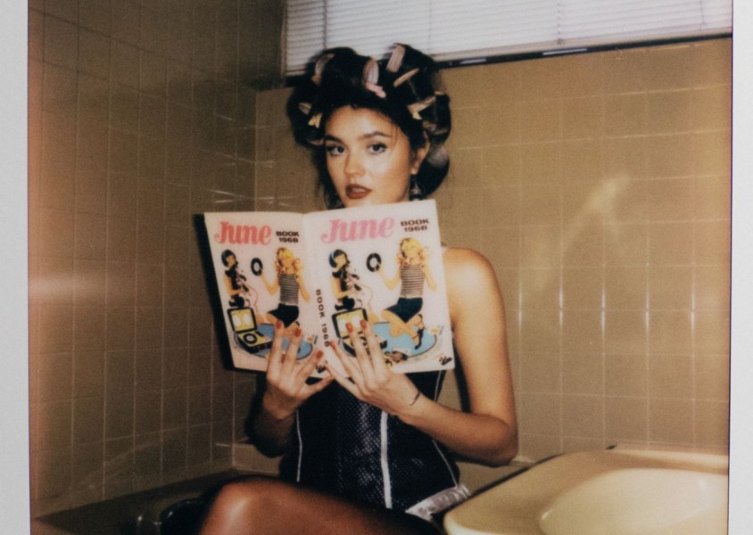 Ruby Roberts holding a magazine with rollers in her hairx